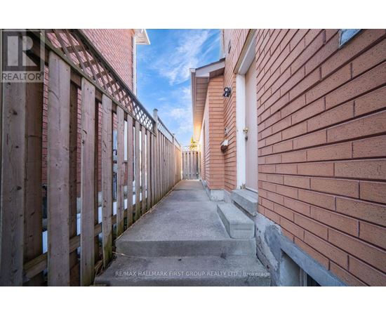 A long, narrow alleyway between two red brick buildings.