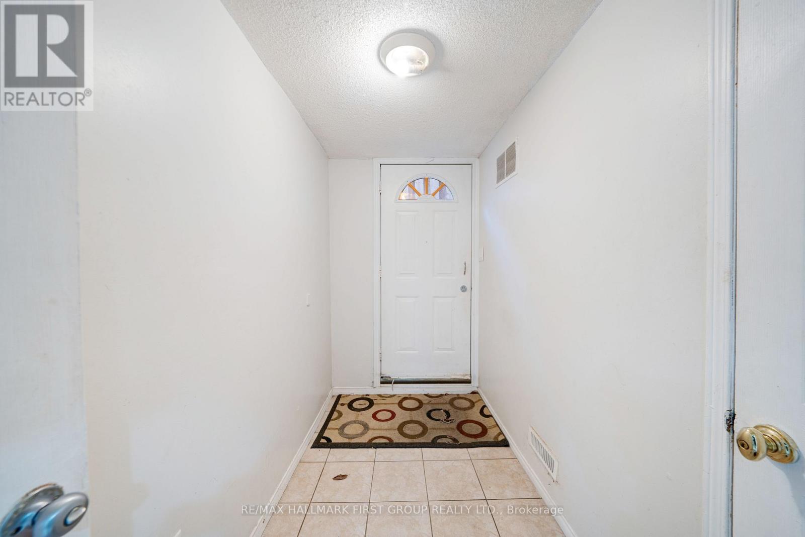 A hallway with a door and a tiled floor.