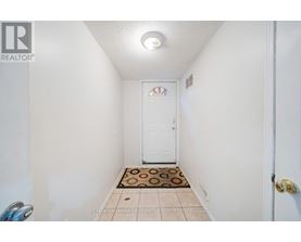 A hallway with a door and a tiled floor.