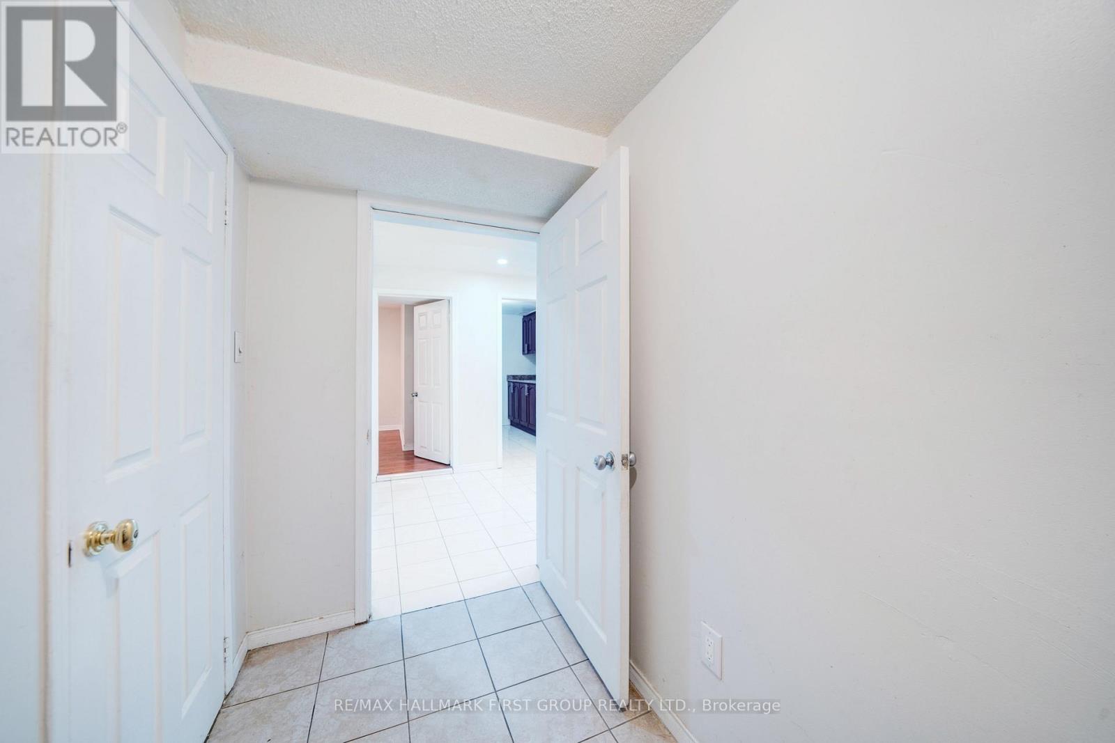 A hallway with a white door and a white wall.