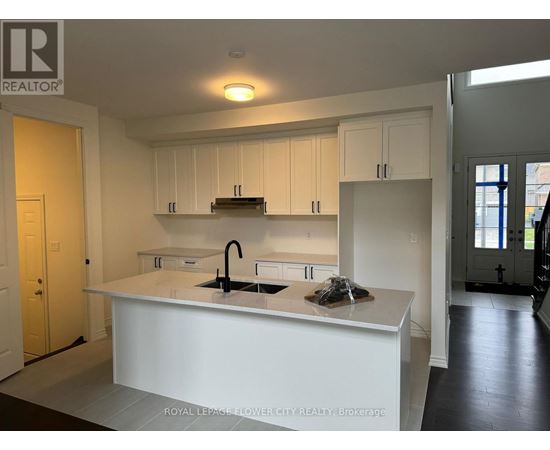 A kitchen with white cabinets and a white island with a sink.