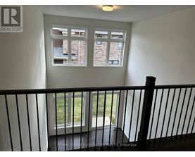 A balcony with a black railing and a window showing a view of a building.