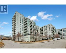 A large, modern apartment building with a parking lot in front.