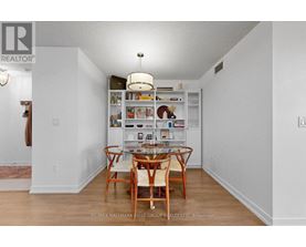 A dining room with a table and chairs.