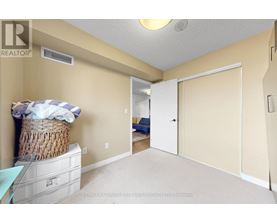 A bedroom with a bed and a wicker basket on a dresser.