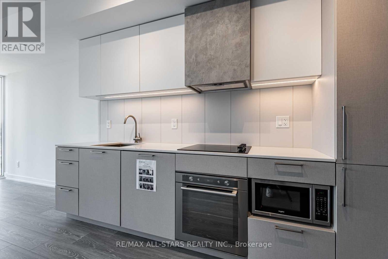 A modern kitchen with white cabinets and stainless steel appliances.