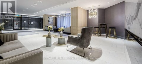 A modern living room with a grey sofa and a black chair.
