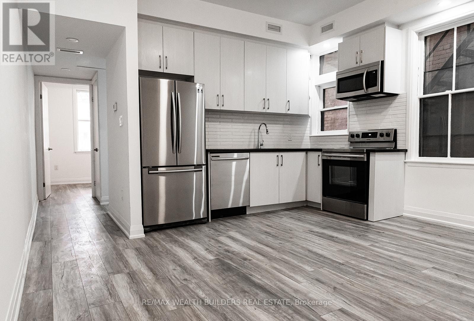 A modern kitchen with stainless steel appliances and white cabinets.