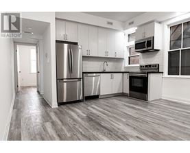 A modern kitchen with stainless steel appliances and white cabinets.