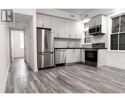 A modern kitchen with stainless steel appliances and white cabinets.