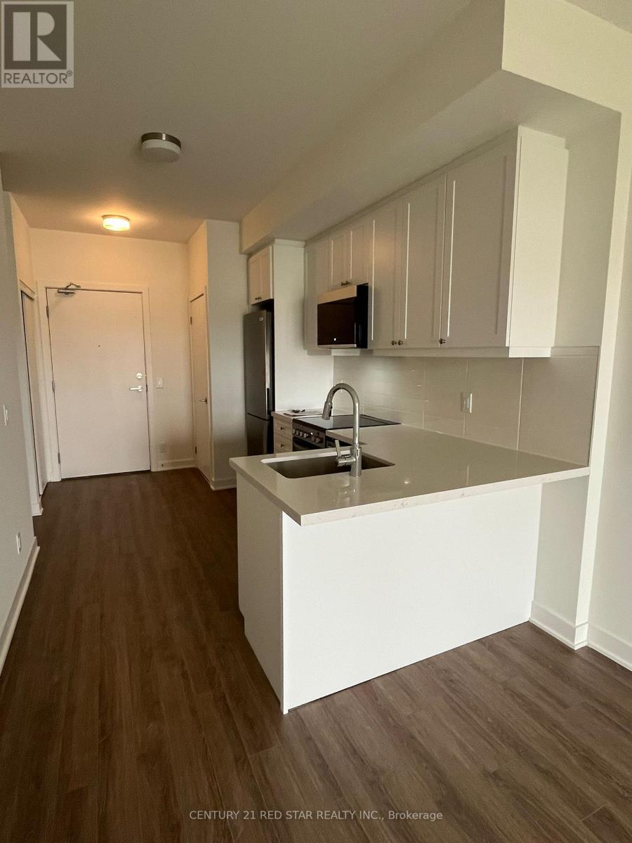 A kitchen with white cabinets and a wooden floor.