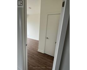 A white door is in a room with wood flooring.