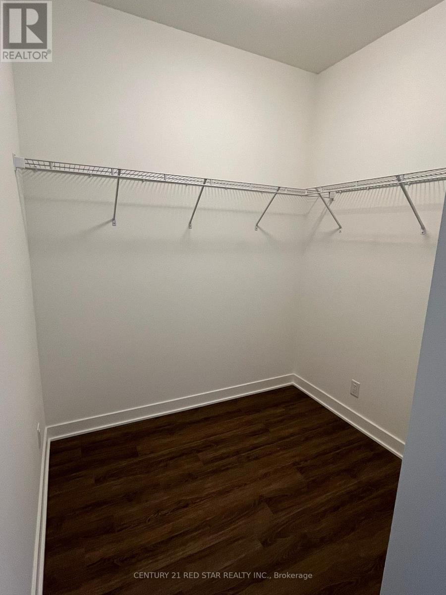 A room with white walls and wooden flooring with clothes hangers on the rail.