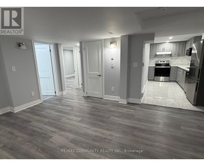 A spacious room with a kitchen area in the background.