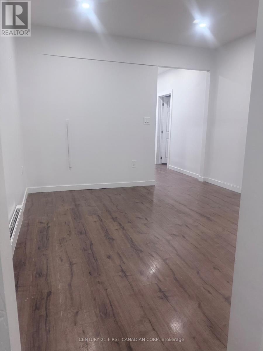 A room with wooden flooring and white walls.
