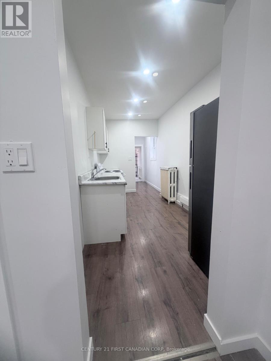 A hallway with wood flooring and white walls.