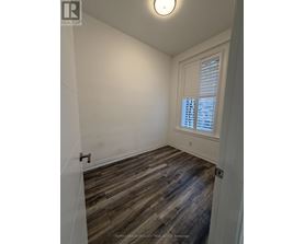 A room with wooden flooring and a window with blinds.