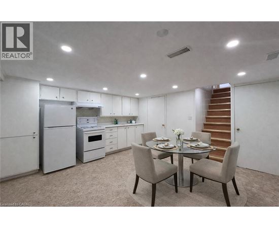 A dining room with a table set for two and a staircase in the background.