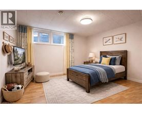 A bedroom with a bed, dresser, and window.