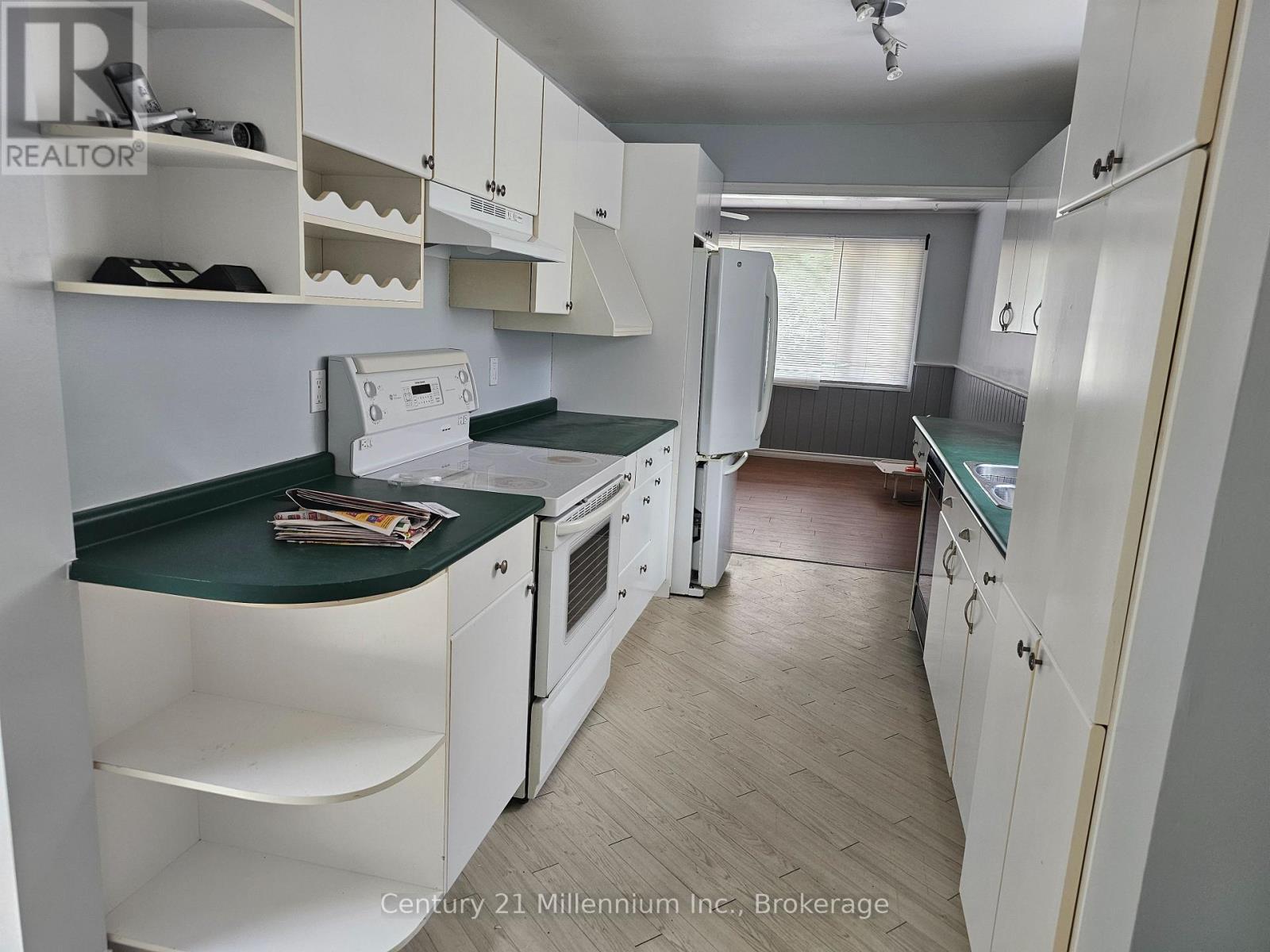 A kitchen with white cabinets and a green countertop.