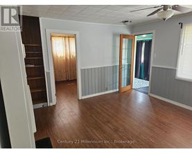 A room with wood flooring and a ceiling fan.