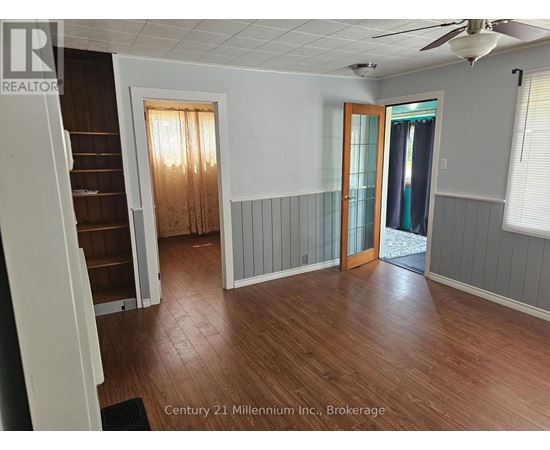 A room with wood flooring and a ceiling fan.