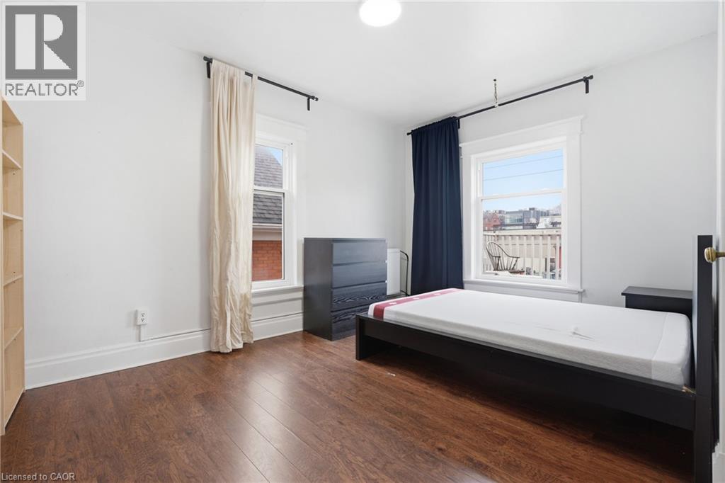 A bedroom with a large bed and a window overlooking a cityscape.