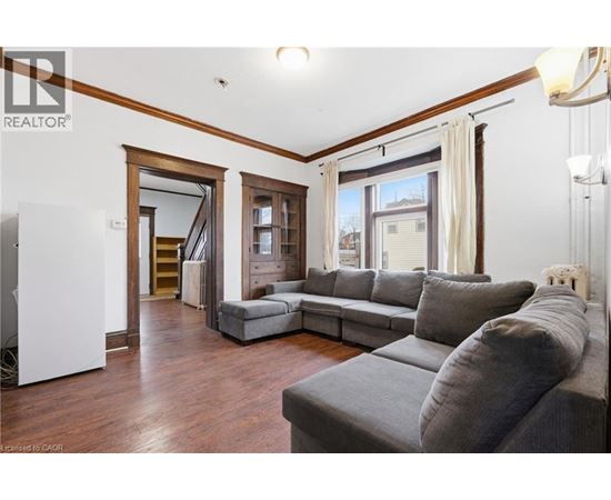 A living room with a grey couch and a white sideboard.