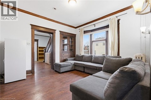 A living room with a grey couch and a white sideboard.