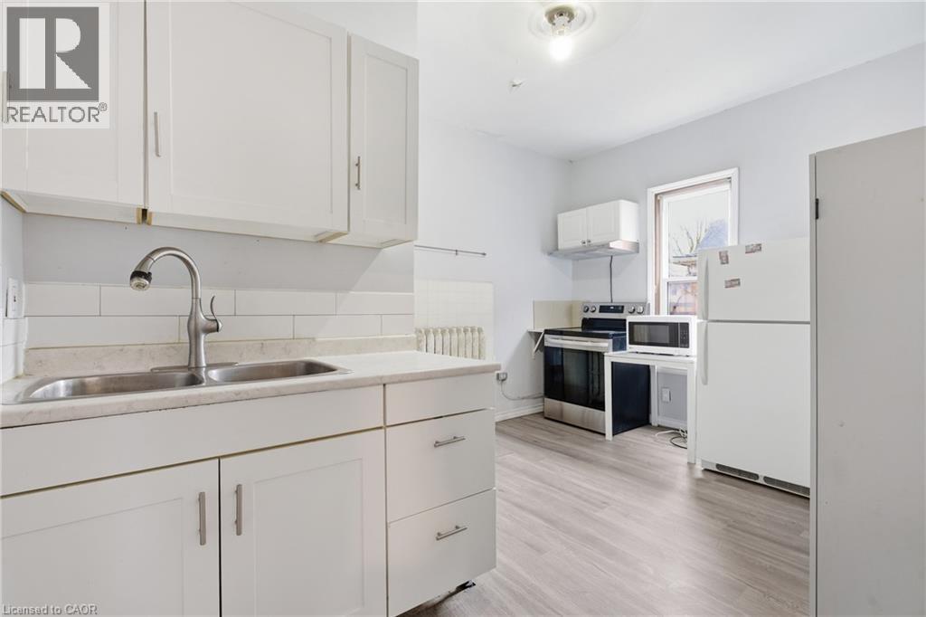 A kitchen with white cabinets and a sink.