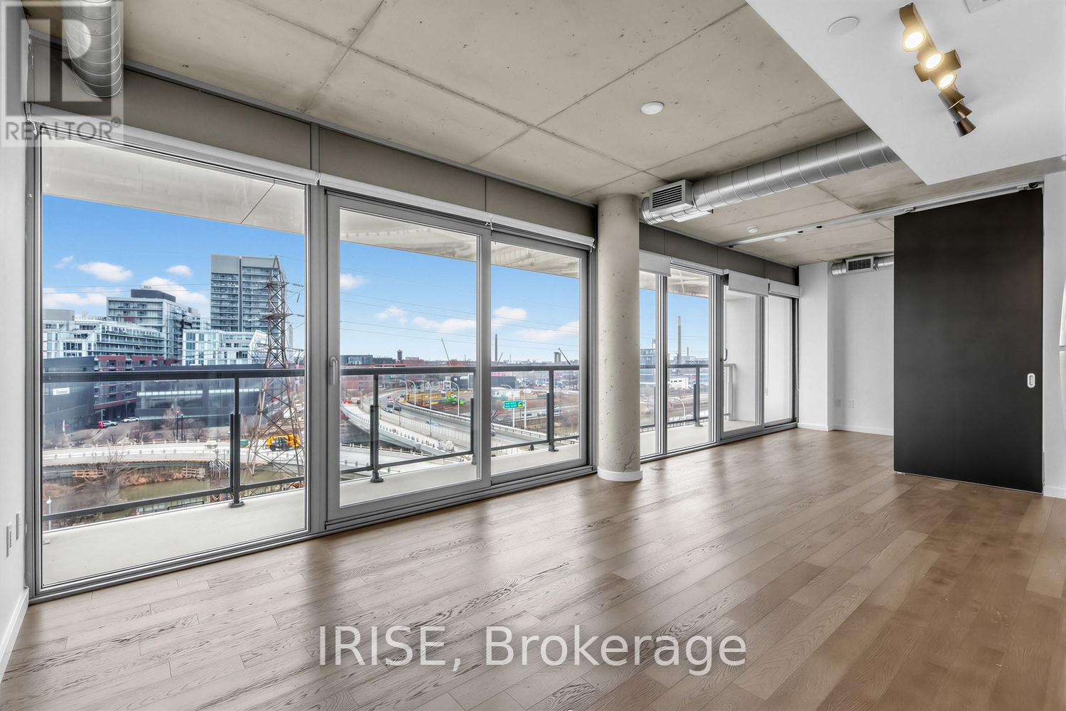A spacious room with a view of the city through large windows.