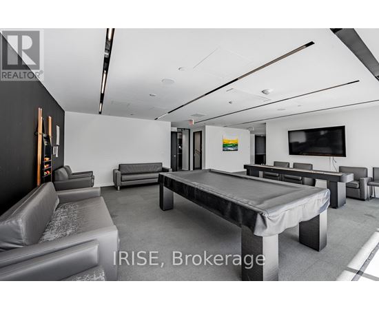 A modern living room with a pool table and a television.
