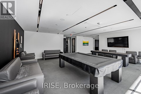 A modern living room with a pool table and a television.