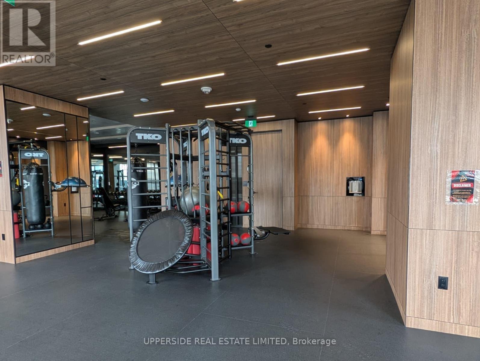 A gym with a variety of equipment including weights and a treadmill.
