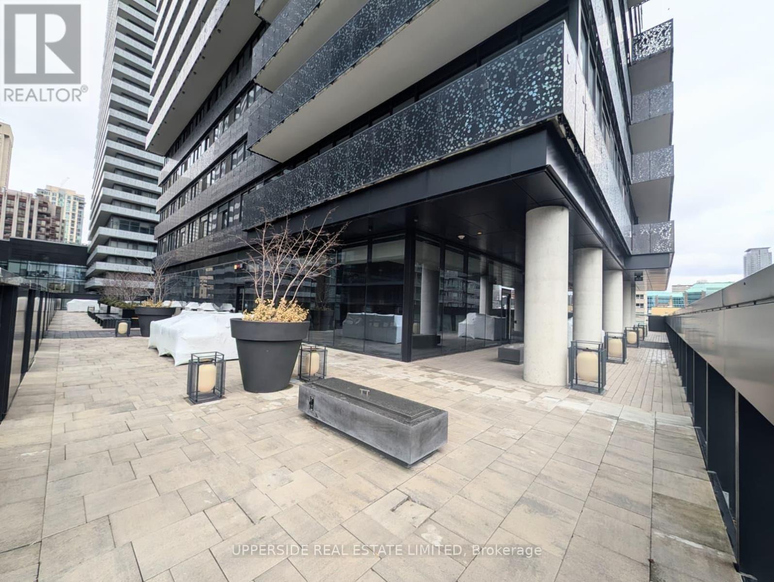 A modern building with a glass facade and a stone walkway in front.