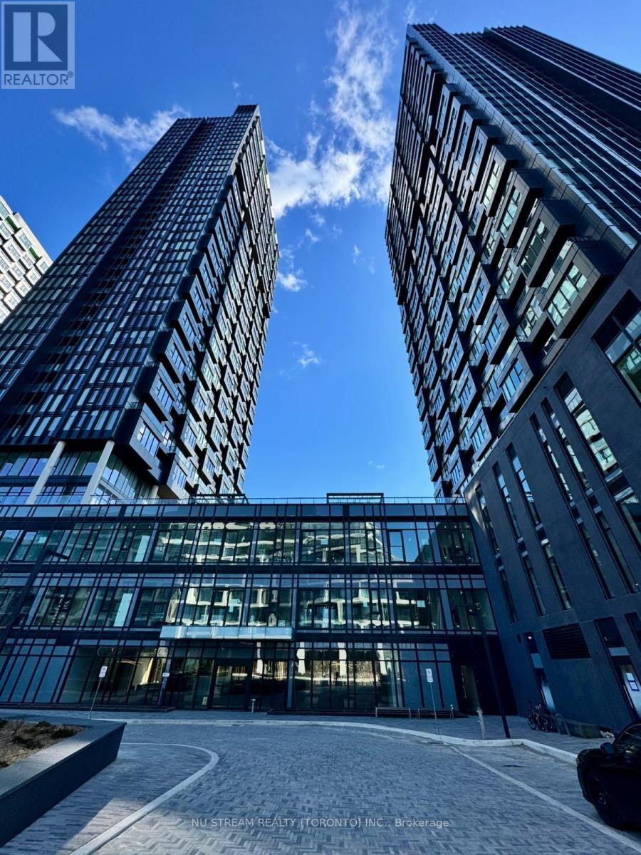 Two tall buildings with glass windows and a car parked in front of them.