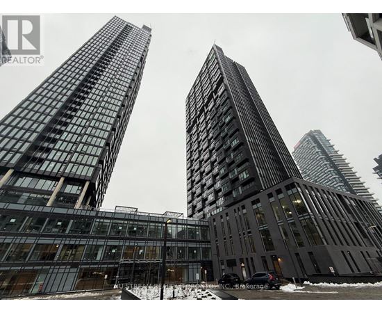 Two tall buildings with glass windows and a car parked in front of them.