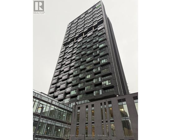 A tall building with many windows is the main focus of the image.