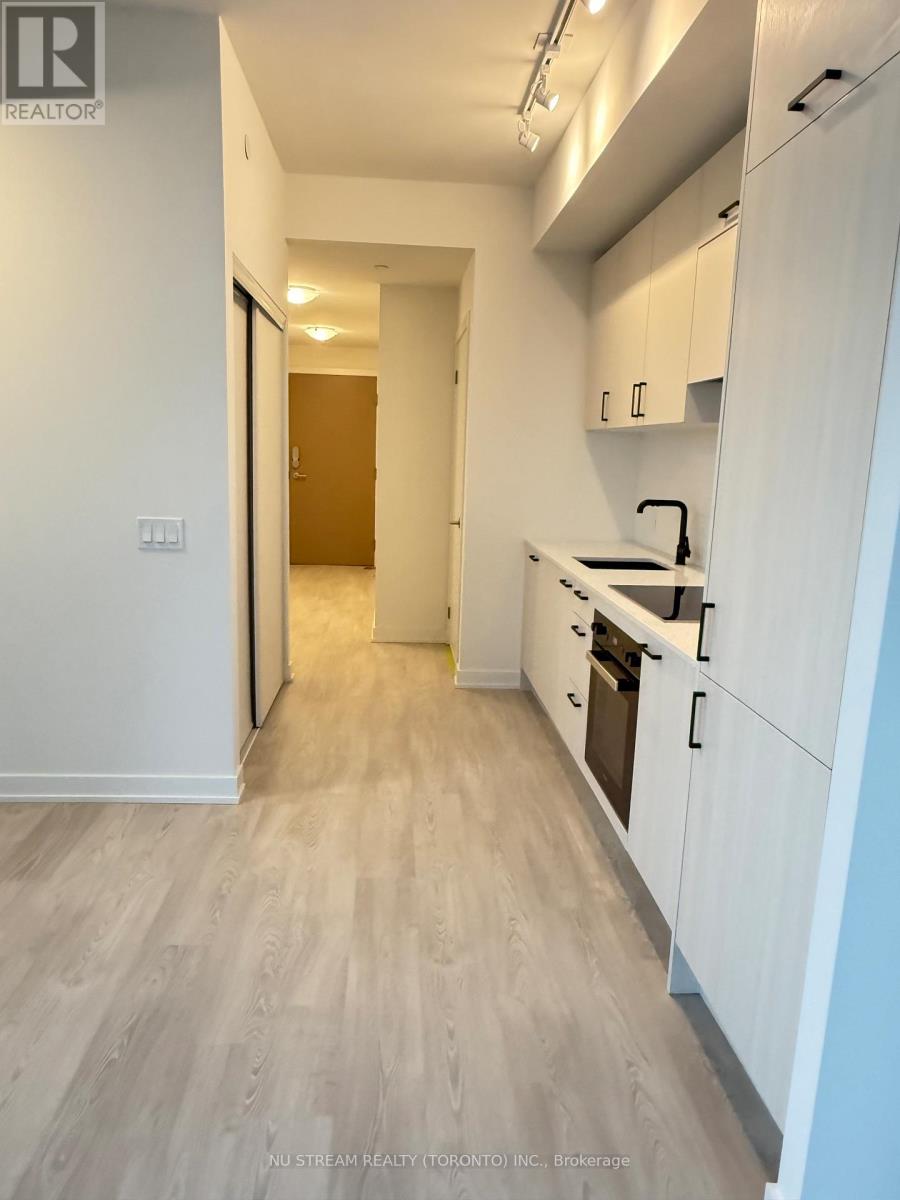 A kitchen with white cabinets and a wooden floor.