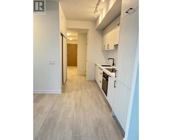 A kitchen with white cabinets and a wooden floor.