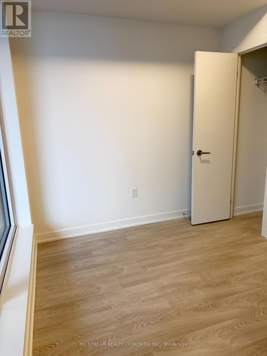 A room with a white door and wooden flooring.