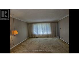 A room with a lamp and a window with curtains.