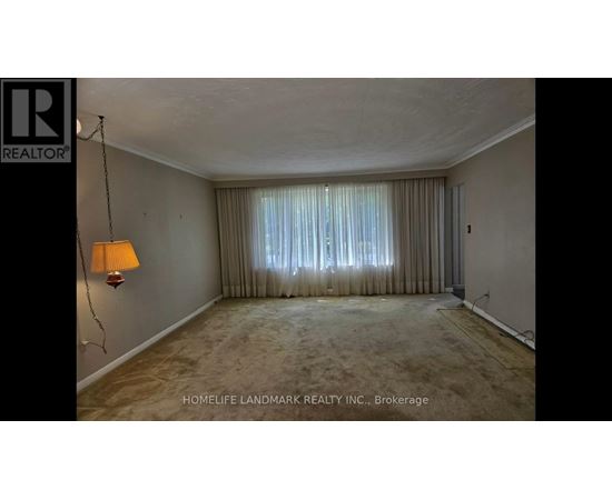 A room with a lamp and a window with curtains.