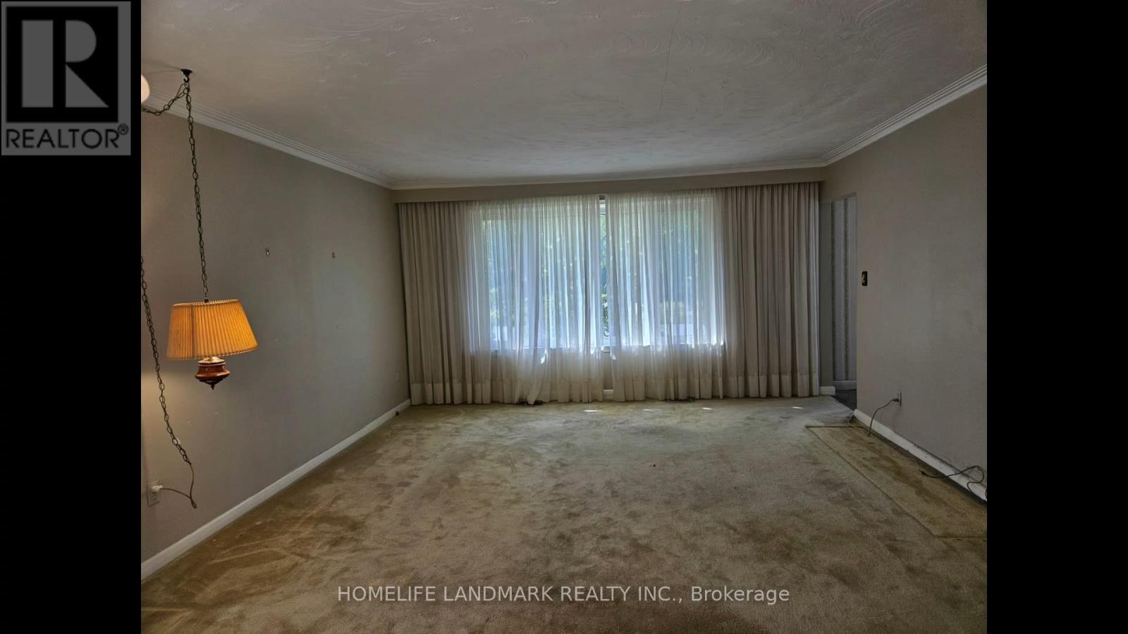 A room with a lamp and a window with curtains.