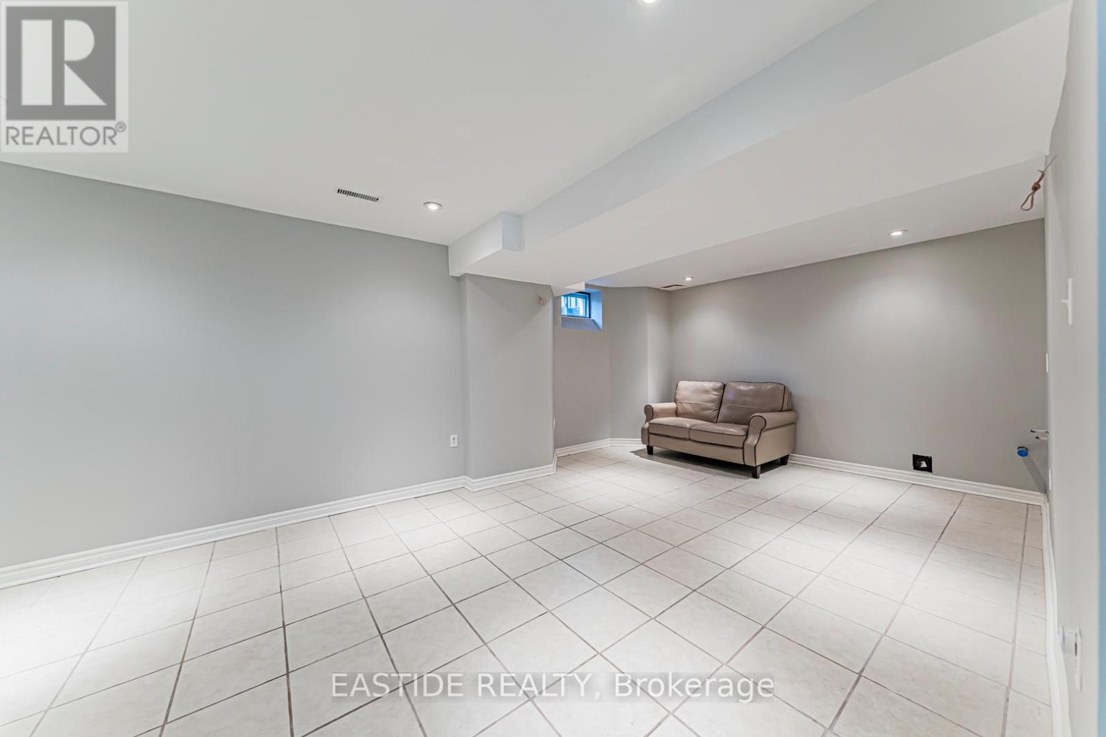 A spacious room with a couch and a flat screen TV.