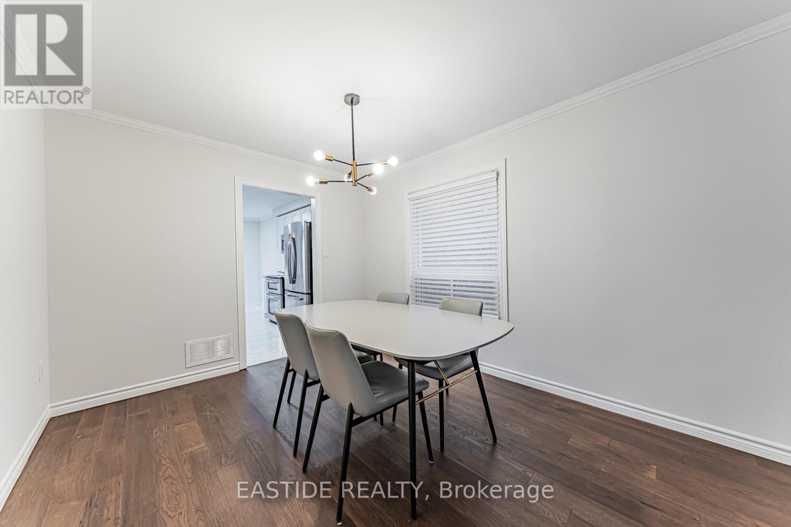 A dining room with a table and chairs.