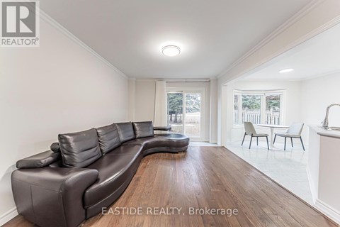 A living room with a brown leather couch and a white wall.