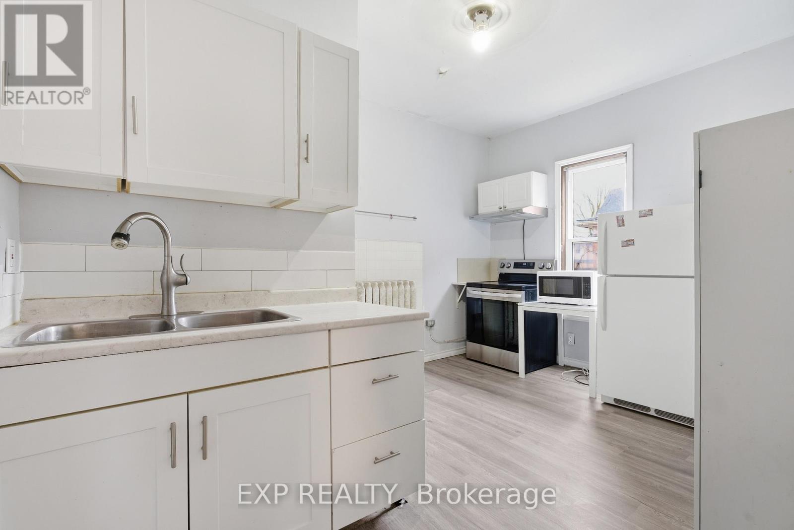 A kitchen with white cabinets and a sink.