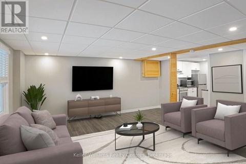 A living room with a grey couch, a black coffee table, and a flat screen TV mounted on the wall.