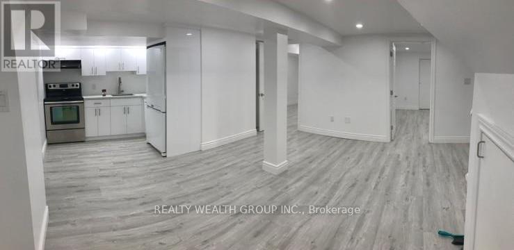 A spacious room with a kitchen area and a dining table.